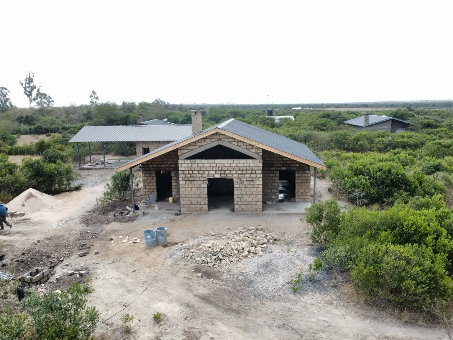 Front elevation progress view of the Sweetwaters holiday-home bungalow showing its stone walling, pitched roof and covered veranda.